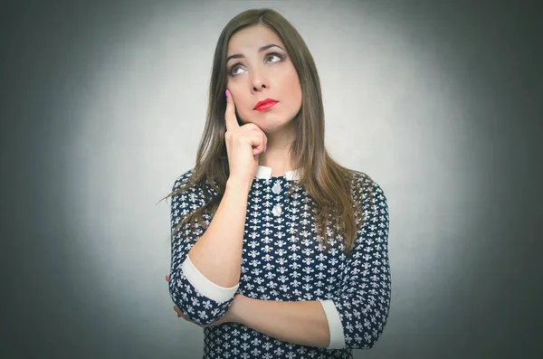 Dalgın dalgın merak ve gri arka plan üzerinde izole düşünme kadındır. Çözüm veya yeni fikirler arıyor.