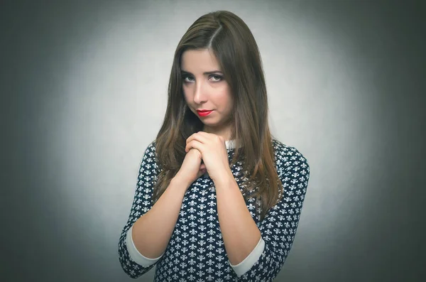 Pensive modest woman. Guilty girl is ashamed isolated on gray background.