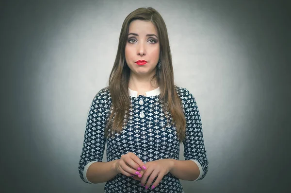 Dalgın mütevazı kadın. Gri arka plan üzerinde izole suçlu kız utanıyor.