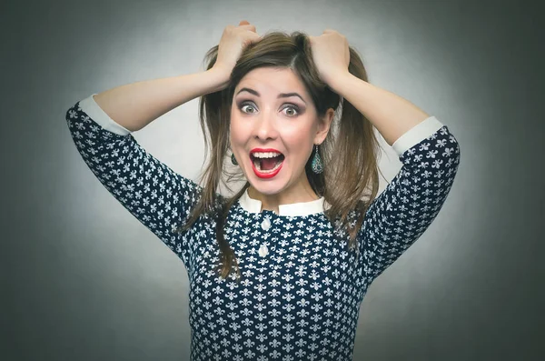 Şok sürpriz kadın saçlarını tarafından elleri üzerinde bir kafa tutuyor ve izole üzerinde gri arka planda çığlık atıyor. Aniden. Kazanmak.