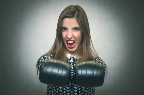 Angry confident woman in boxing gloves are shouting isolated on gray backgroung. Wicked dissatisfied wife. Female rivalry.