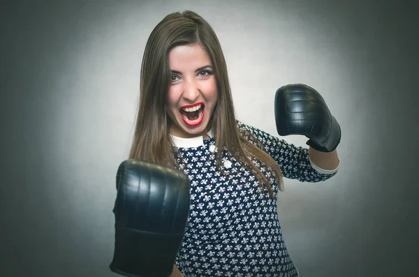 Angry confident woman in boxing gloves are shouting isolated on gray backgroung. Wicked dissatisfied wife. Female rivalry.