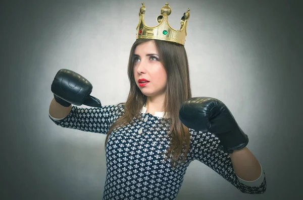 Altın taç başında ve boks eldivenleri ile kızgın kendine güvenen kadın. Kötü ruh kavramı ukala kız. Memnun karısı. Kadın maç. Kadın güzellik yarışması kavramı. Kadın rekabet.