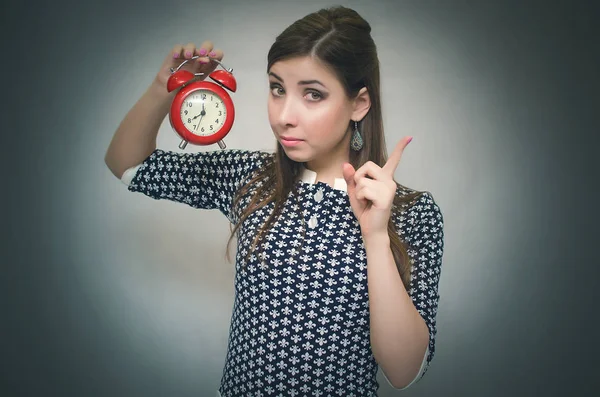 Eller kırmızı alarm masa saati içinde tutan ve bir işaret parmağı gösterilen sıkı patron kadın. İş veya okul geç uyarı kavramı. Azarlama kilise fazla uyumak.