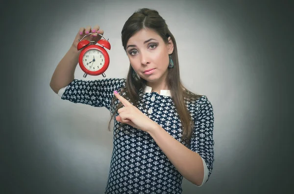 Eller kırmızı alarm masa saati içinde tutarak ve zaman onun parmağı tarafından gösterilen sıkı patron kadın. İş veya okul geç uyarı kavramı. Azarlama kilise fazla uyumak.