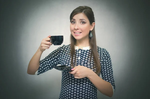 Kahve molası. Kahve zamanı. Öğle yemeği molası. Bir fincan kahve gri arka plan üzerinde izole elinde tutan mutlu gülümseyen kadın.