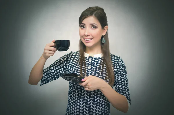 Kahve molası. Kahve zamanı. Öğle yemeği molası. Bir fincan kahve gri arka plan üzerinde izole elinde tutan mutlu gülümseyen kadın.