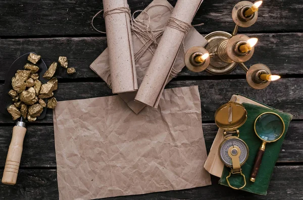 Hazine harita, pusula, Büyüteç, seyahat günlüğü kitap ve kürek tam altın nuggets cevheri ahşap masa üzerinde kopya alanı olan boş kağıt sayfası. Hazine avcısı veya altın madenci kavramı.