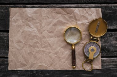 Hazine harita, pusula ve Büyüteç Camı eski macera tablo arka plan üzerinde kopya alanı boş buruşuk sayfayla.