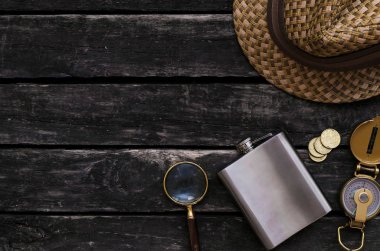 Maceracı tablo. Seyahat kavramı. Pusula, Büyüteç, şişesi, şapka ve eski ahşap masa arka plan kopya alanı ile para.