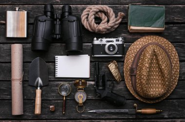 Not defteri, pusula, dürbün, film fotoğraf makinesi, Büyüteç, hançer, tabanca, günlüğü kitap, kürek, ip, altın cevheri ve eski kaydırma belge maceracı veya explorer ahşap masa üzerinde. Gezgin.