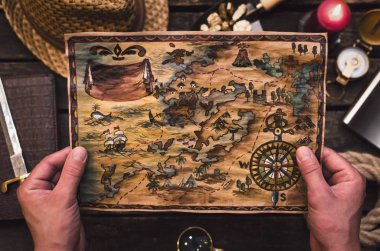 Hazine avcısı elinde hazine haritası. Korsan adam kırmızı işareti ile eski bir harita öğrenme.