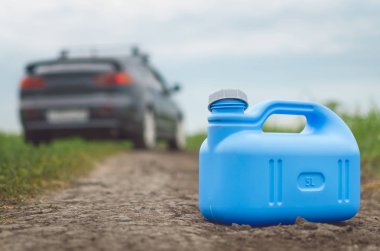 Benzin son kavramı. Yeterli yakıt. Boş yakıt teneke kutu ve araba yol arka plan üzerinde.