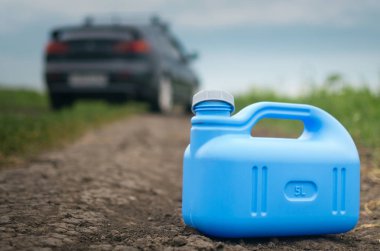 Benzin son kavramı. Yeterli yakıt. Boş yakıt teneke kutu ve araba yol arka plan üzerinde.