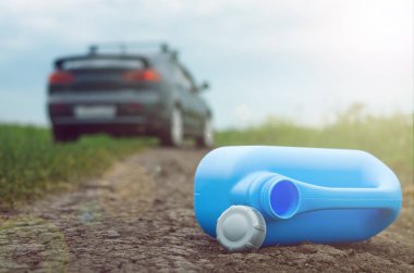 Benzin son kavramı. Yeterli yakıt. Boş yakıt teneke kutu ve araba yol arka plan üzerinde.