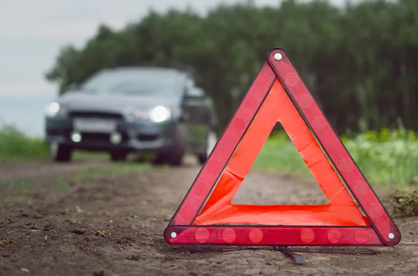 Araba arızası değil yeterli yakıt. Kırmızı acil üçgen dur işareti ve yolda araba.