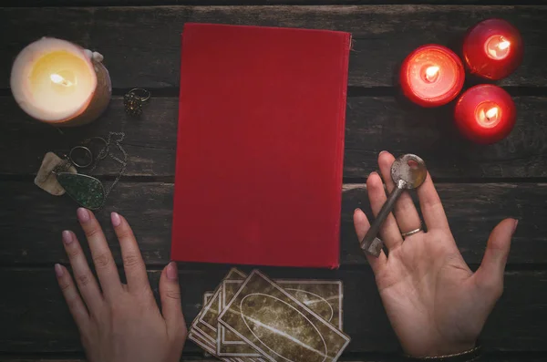 Key to secrets of fate, magic book and tarot cards on fortune teller table background.