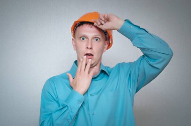 Şok Oluşturucusu çalışan adam elini onun baş üzerinde izole gri arka plan üzerinde tutuyor.