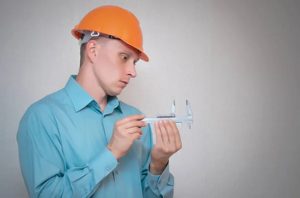 Construtor Mede Algo Usando Paquímetro Suas Mãos Isolado Fundo Cinza — Fotografia de Stock