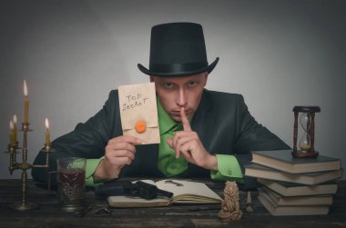 Melon adam elinde en iyi gizli belgelerle masaya oturuyor. Dedektif veya casus ajan veya polis müfettişi kavramı.