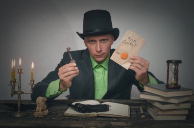 Melon erkekte el ve unravelling ipucu anahtarı üst gizli belgelerle masaya oturuyor. Dedektif veya casus ajan veya polis müfettişi kavramı.