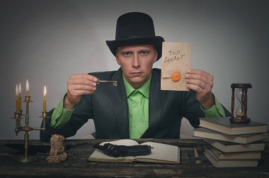 Melon erkekte el ve unravelling ipucu anahtarı üst gizli belgelerle masaya oturuyor. Dedektif veya casus ajan veya polis müfettişi kavramı.