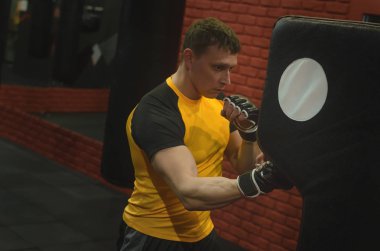 Bir boksör bir yumrukta yere delme armut trenler.