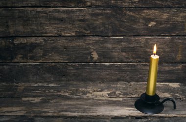 Yaşlı ahşap masa arka plan üzerinde yanan mum.
