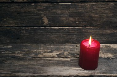 Yaşlı ahşap masa arka plan üzerinde yanan mum.