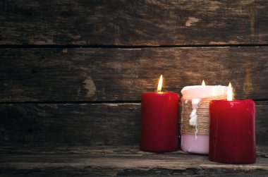 Yaşlı ahşap masa arka plan üzerinde yanan mum.