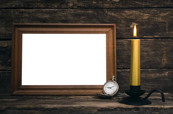 Leerer Fotorahmen Taschenuhr Und Brennende Kerze Auf Gealtertem Holztischhintergrund — Stockfoto