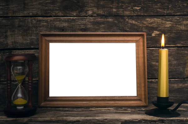 Empty Photo Frame Sand Watch Burning Candle Aged Wooden Table — Stock Photo, Image