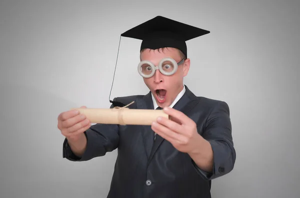 高兴的研究生在盖帽与文凭证书被隔绝在灰色背景 教育理念 — 图库照片