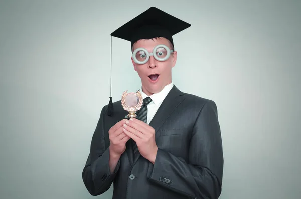 Aufgeregter Doktorand Mit Schirmmütze Auf Grauem Hintergrund Bildungskonzept — Stockfoto