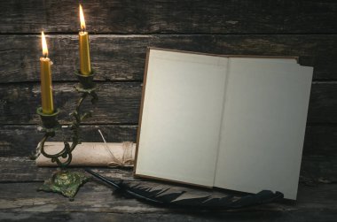 Yanan mum ışığında boş boş sayfaları ile açık bir kitap. Yazar ya da yazar kavramı.