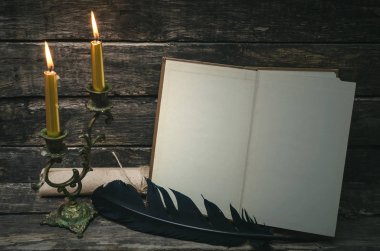 Yanan mum ışığında boş boş sayfaları ile açık bir kitap. Yazar ya da yazar kavramı.