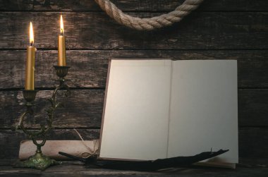 Yanan mum ışığında boş boş sayfaları ile açık bir kitap. Yazar ya da yazar kavramı.