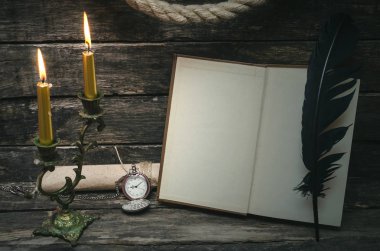 Yanan mum ışığında boş boş sayfaları ile açık bir kitap. Yazar ya da yazar kavramı.