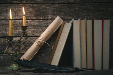 Yanan mum ışığında masada kitap yığını. Yazar ya da yazar kavramı. Okula dönüş.