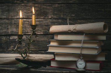 Yanan mum ışığında retro masasında kitap yığını. Yazar ya da yazar kavramı. Okula dönüş.