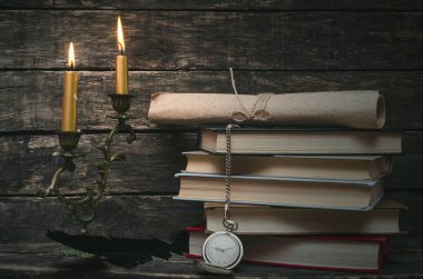 Yanan mum ışığında retro masasında kitap yığını. Yazar ya da yazar kavramı. Okula dönüş.
