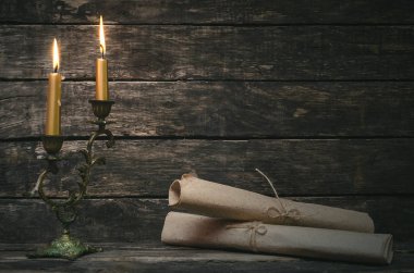 Yanan mum ışığında kağıt sayfaları kaydırılan kaydırma. Eski mektup. Yazar ya da yazar kavramı.