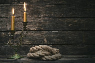 İp demirleme ve korsan arka plan kopya alanı ile yaşında tahta masada canlde yanan.