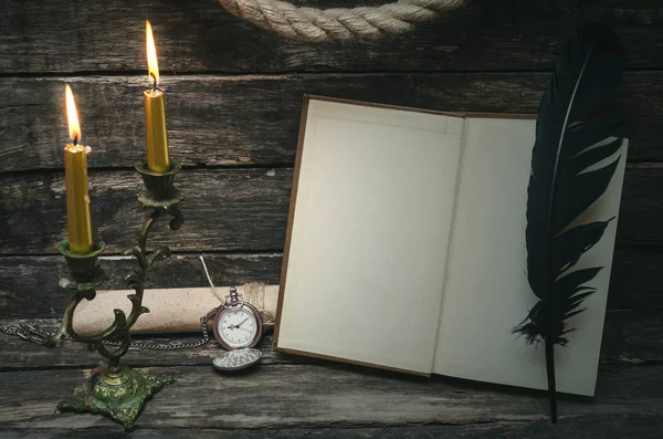 Yanan mum ışığında boş boş sayfaları ile açık bir kitap. Yazar ya da yazar kavramı.