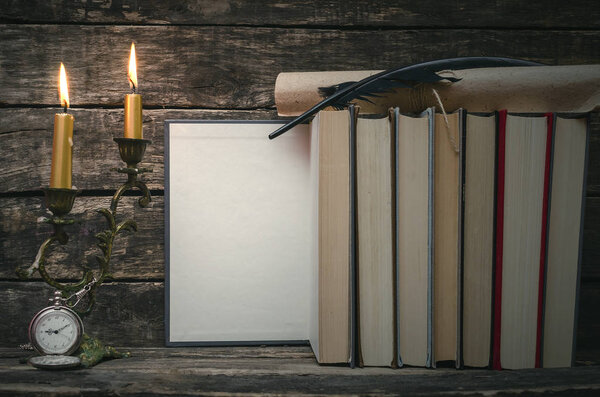 Open book with blank empty pages in the light of burning candle. Writer or author concept.