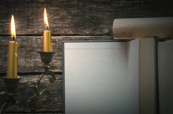 Yanan mum ışığında boş boş sayfaları ile açık bir kitap. Yazar ya da yazar kavramı.