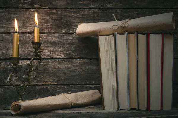 Yanan mum ışığında masada kitap yığını. Yazar ya da yazar kavramı. Okula dönüş.