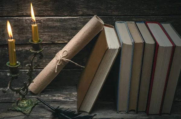 Yanan mum ışığında masada kitap yığını. Yazar ya da yazar kavramı. Okula dönüş.