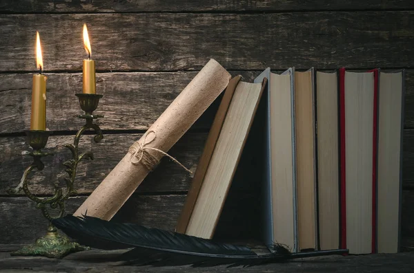 Yanan mum ışığında masada kitap yığını. Yazar ya da yazar kavramı. Okula dönüş.
