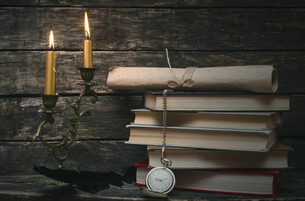 Yanan mum ışığında retro masasında kitap yığını. Yazar ya da yazar kavramı. Okula dönüş.